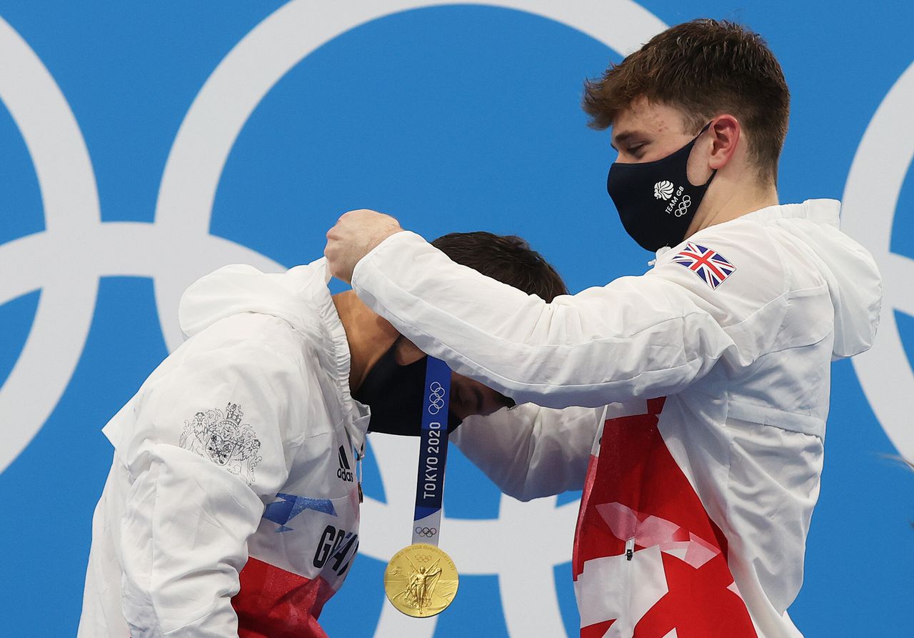 Great Britain's Tom Daley receives a gold medal from teammate Matty Lee during the medal presentation for the men's synchronized 10 meter platform event on July 26.