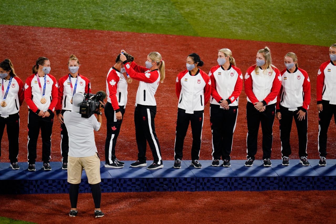 Members of Team Canada receive their bronze medals on the podium during the medal ceremony for softball on July 27 in Yokohama.