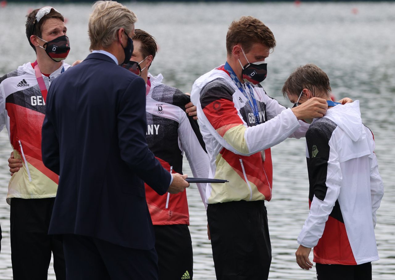 German rower Hannes Ocik places a silver medal around the neck of cox Martin Sauer after the men's eight final on July 29.