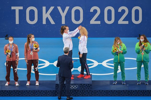 テニス女子ダブルスで、チェコ代表として初の金メダルを獲得し、ペアを組んだカテリナ・シニアコバ選手（中央右）にメダルをかけるバルボラ・クレイチコバ選手（同左）