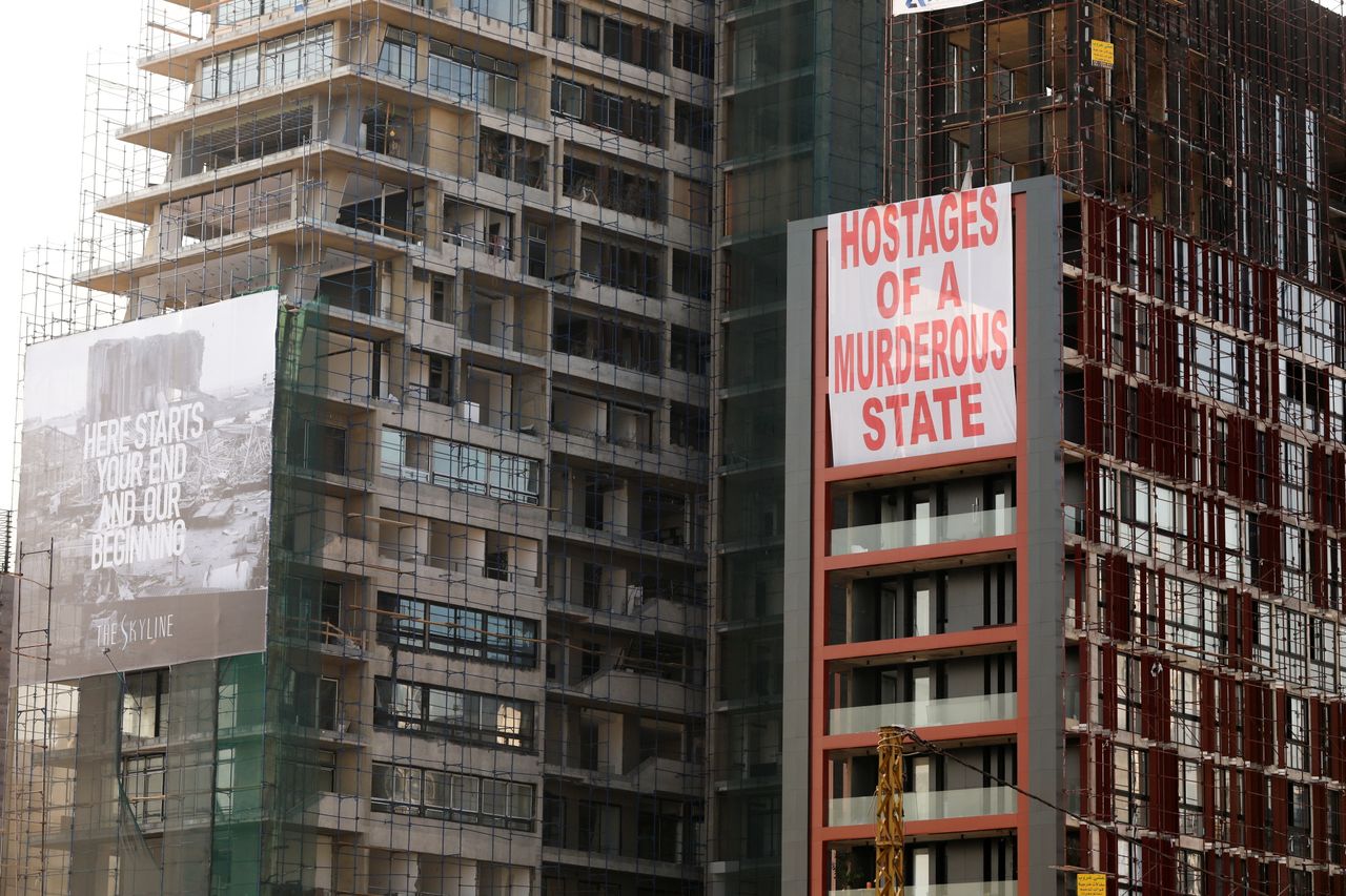 Banners reading "Hostages of a murderous state" on a building damaged in the blast.