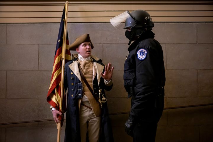 A protester dressed as George Washington debates with a Capitol Police officer on Jan. 6, 2021.