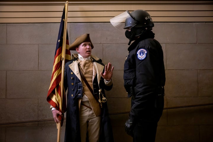 A protester dressed as George Washington debates with a Capitol Police officer on Jan. 6, 2021.