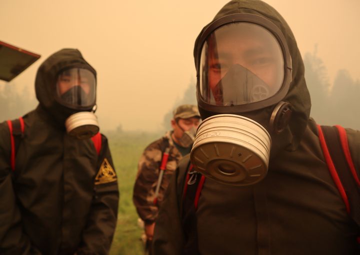 Πυροσβέστες με προστατευτικές μάσκες σε φωτιά κοντά στο χωριό Μαγκάρας στην περιοχή Γιακούτια της Ρωσίας 17 Ιουλίου, 2021. Picture taken July 17, 2021. REUTERS/Roman Kutukov