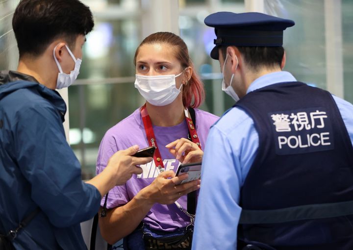 羽田空港で8月1日に警察官らと話をするツィマノウスカヤ選手。