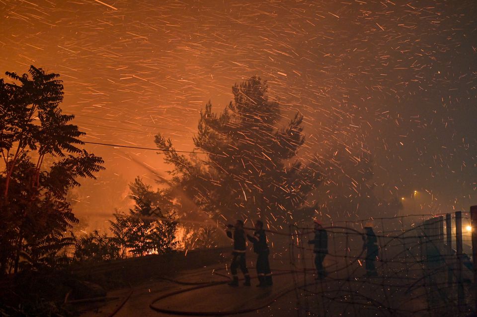 An Athens suburb is engulfed in flames during a