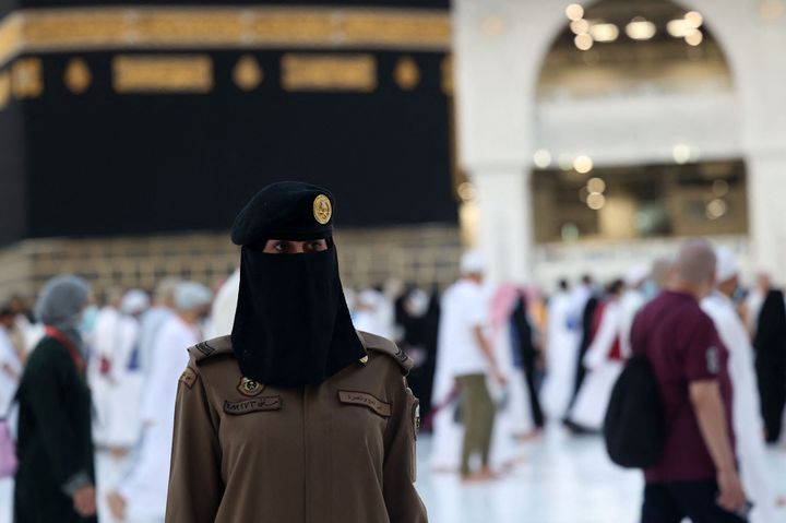 A Saudi policewoman stands guard as worshippers go around the Kaaba, Islam's holiest site.