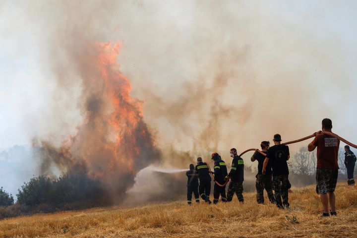 Πυροσβέστες και εθελοντές δίνουν τη μάχη μαζί για να ανακόψουν την εξάπλωση του τεράστιου μετώπου κοντά στον Άγιο Στέφανο. 6 Αυγούστου 2021. REUTERS/Costas Baltas