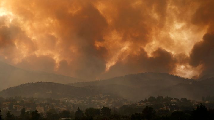 Smoke spreads over Parnitha mountain during a wildfire in Ippokratios Politia village, about 35 kilometres (21 miles), northern Athens, Greece, Friday, Aug. 6, 2021. 