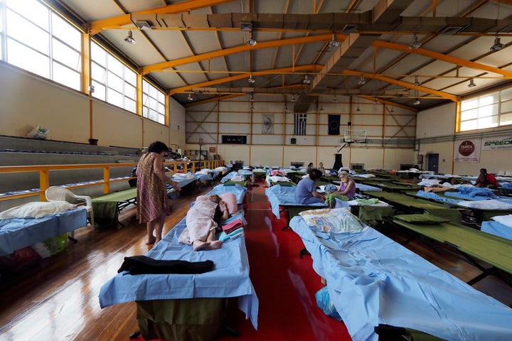 People who fled their homes during wildfires are accommodated at an indoor hall in Chalkida the capital of Evia island, about 81 kilometers (50 miles) north of Athens, Greece, Saturday, Aug. 7, 2021. 