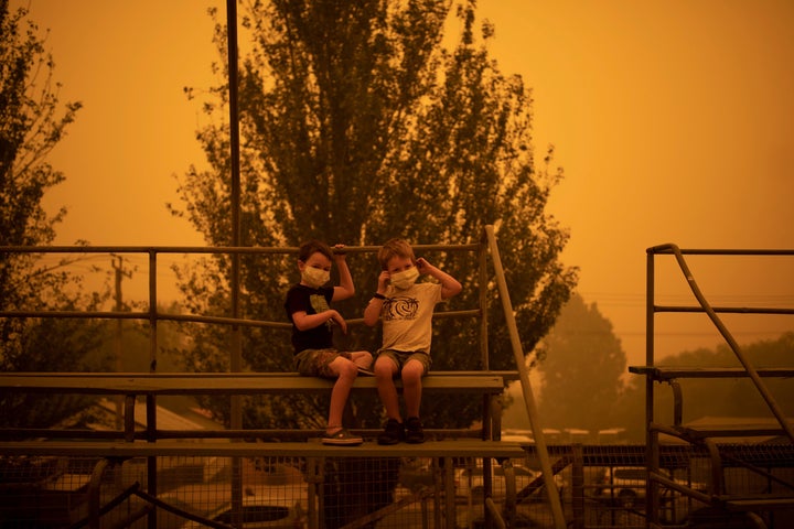 Children wear masks as they play at the showgrounds in the southern New South Wales, Australia, town of Bega where people were camping after being evacuated from nearby sites affected by bushfires in December 2019.