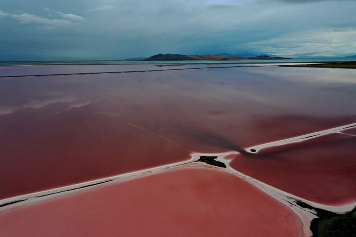 In an aerial view, evaporation ponds that are pinkish-red due to high salinity levels are visible on the north section of the