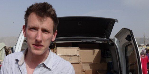 FILE - In this undated file photo provided by his family, Peter Kassig stands in front of a truck filled with supplies for Syrian refugees. The Indianapolis, Indiana, aid worker being held by the Islamic State group told family and teachers that heâd found his calling in 2012 when he decided to stay in the Middle East instead of returning to college, according to an email released Tuesday, Oct. 14, 2014 by his family. (AP Photo/Courtesy Kassig Family, File)