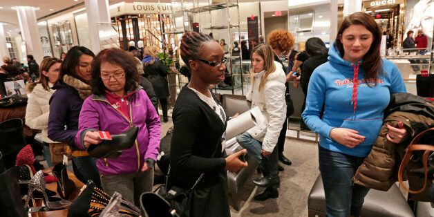 Customers browse shoes at a Macy's Inc. store ahead of Black Friday in New York, U.S., on Thursday, Nov. 27, 2014. An estimated 140 million U.S. shoppers will hit stores and the Web this weekend in search of post-Thanksgiving discounts, kicking off what retailers predict will be the best holiday season in three years. Photographer: Peter Foley/Bloomberg via Getty Images
