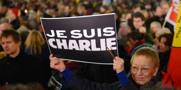 A woman shows a banner reading âI am Charlieâ for the victims of the shooting at the satirical newspaper Charlie Hebdo in Paris during a demonstration of thousands against the right wing PEGIDA movement, 'Patriotic Europeans against the Islamization of the West' in Duesseldorf, Germany, Monday evening, Jan. 12, 2015. (AP Photo/Martin Meissner)