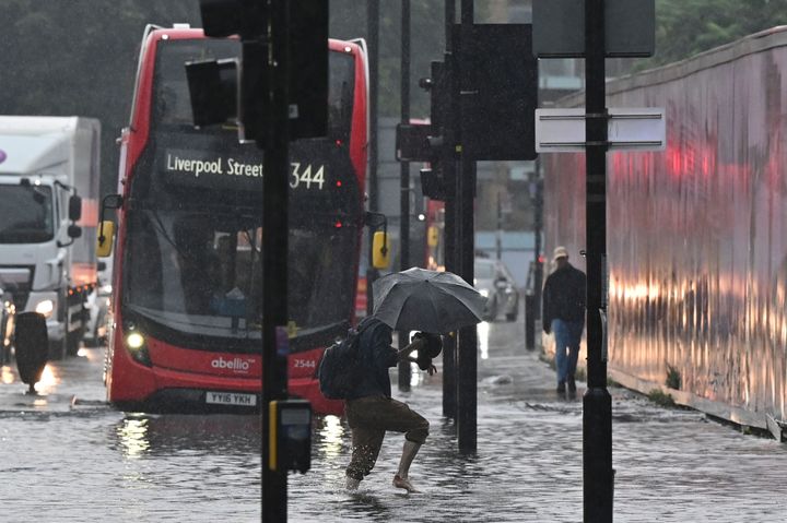 Η προσπάθεια ενός διαβάτη να διασχίσει τους πλημμυρισμένους δρόμους του Λονδίνου. 