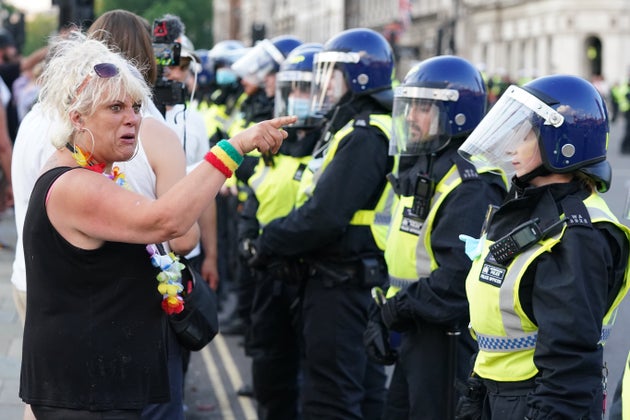 Police maintain a cordon as anti-vaccination protesters look on during a demonstration in Parliament...