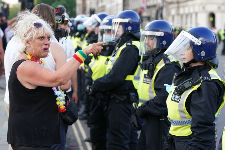 Police maintain a cordon as anti-vaccination protesters look on during a demonstration in Parliament Square, London, on July 19, 2021