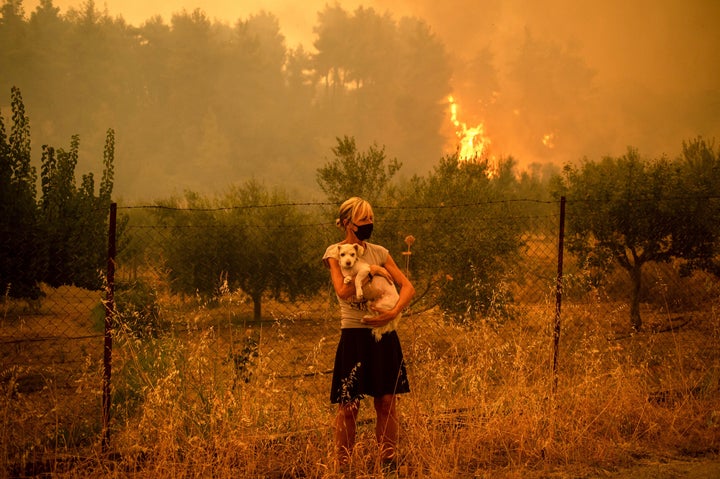 Una mujer con su perro, entre los incendios en la isla de Eubea (Grecia) este 8 de agosto.
