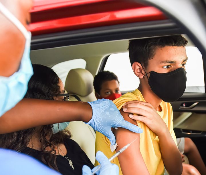 A nurse administers a COVID-19 vaccine to a kid at a drive-thru COVID-19 testing and vaccination site at Barnett Park in Orlando on Aug. 4. 