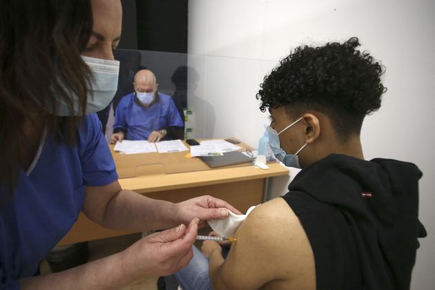 Un jeune homme de 18 ans reçoit une dose du vaccin Comirnaty de Pfizer-BioNTech contre le Covid-19 au centre de vaccination d'Ajaccio en Corse, le 13 mai 2021. La vaccination est ouverte aux personnes de plus de 18 ans depuis début mai en Corse. (Photo by PASCAL POCHARD-CASABIANCA/AFP via Getty Images)