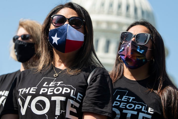Texas state Reps. Mary Ann Perez, center, and Christina Morales, right, attend a news conference with members of the Texas House Democratic Caucus to discuss voting rights and the 56th anniversary of the signing of the Voting Rights Act outside the U.S. Capitol on Friday. The lawmakers were in Washington to deny state Republicans a quorum to pass a law to restrict voting access.