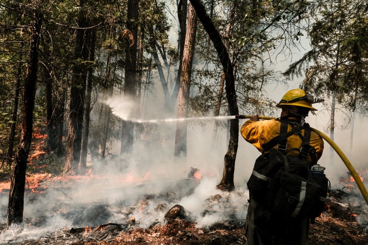 A firefighter employed by J. Franco Reforestation works to extinguish a control burn, a preventative measure to protect a home located on North Valley Road on August 9, 2021 in Greenville, California. (Photo by David Odisho/Getty Images)