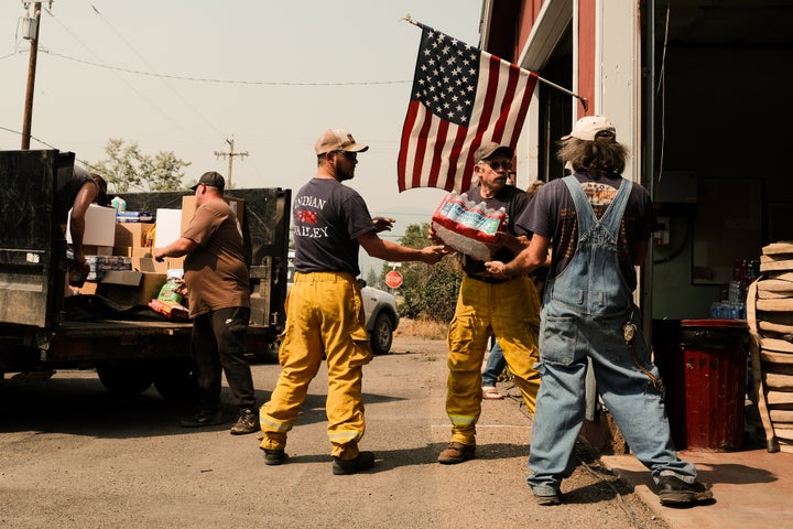 Volunteers haul in supplies to the fire station situated on Nelson Street to serve residents that defied evacuation orders on