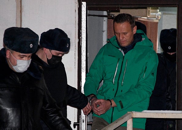 Opposition leader Alexei Navalny is escorted out of a police station on January 18,