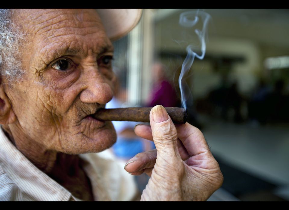 An elderly man smokes a cigar in the San