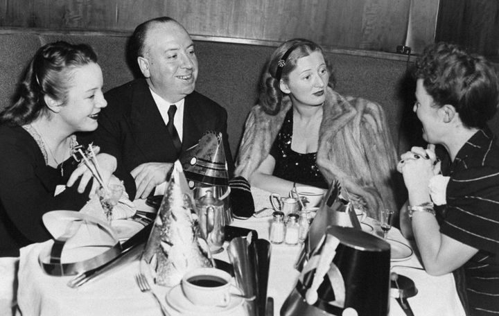 Movie director Alfred Hitchcock is joined by his daughter, Patricia (left); Mrs. Leonard Lyons, wife of the newspaper columnist, and Hitchcock's wife, Alma (right), as they celebrate New Year's Eve over dinner at the Stork Club. 