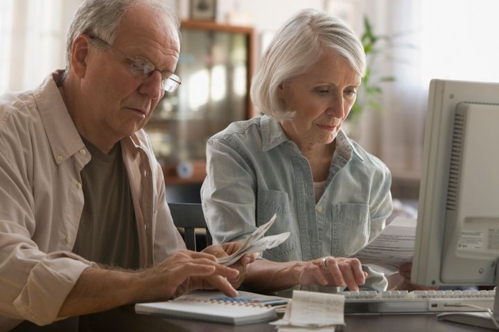 Older couple paying bills on computer