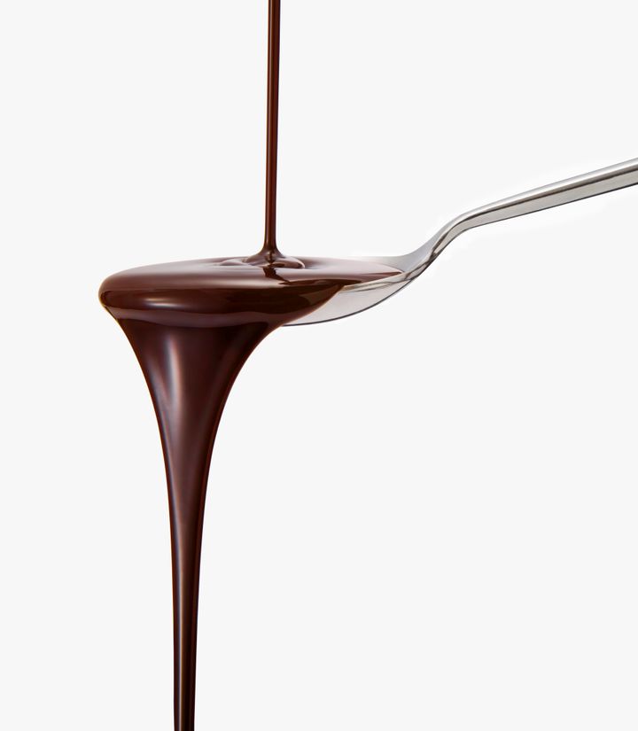 Chocolate sauce dripping from spoon