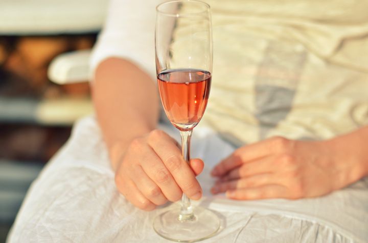 Woman holding glass of rose wine.
