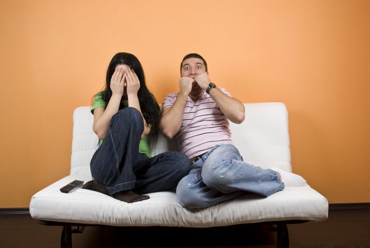 couple watching tv a horror...