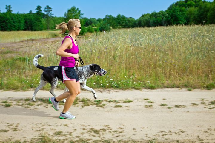 woman runner running with a dog ...