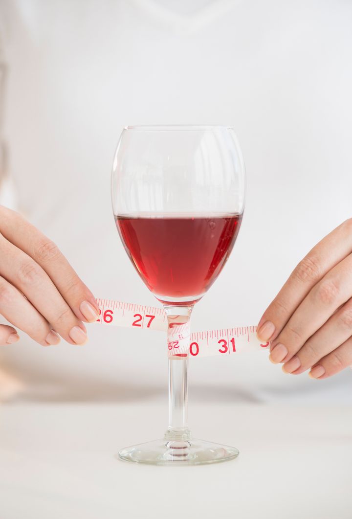 USA, New Jersey, Jersey City, Woman measuring glass with rose wine