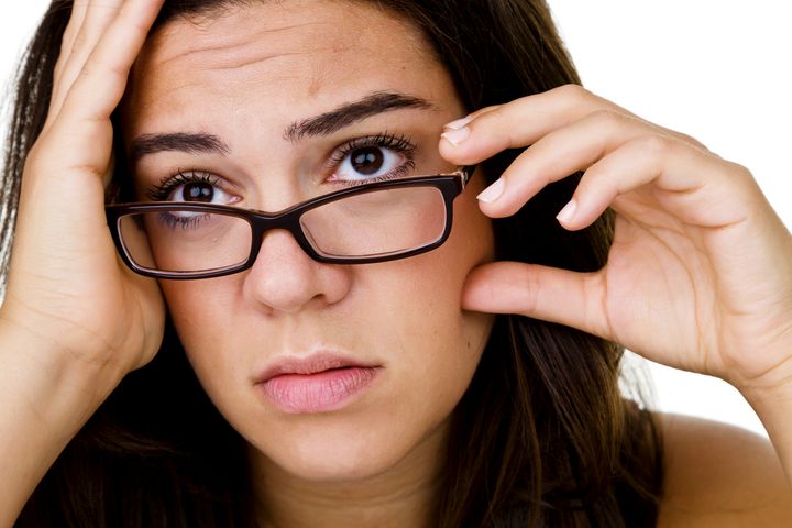 Headshot of a sad girl wearing glasses and looking away from camera