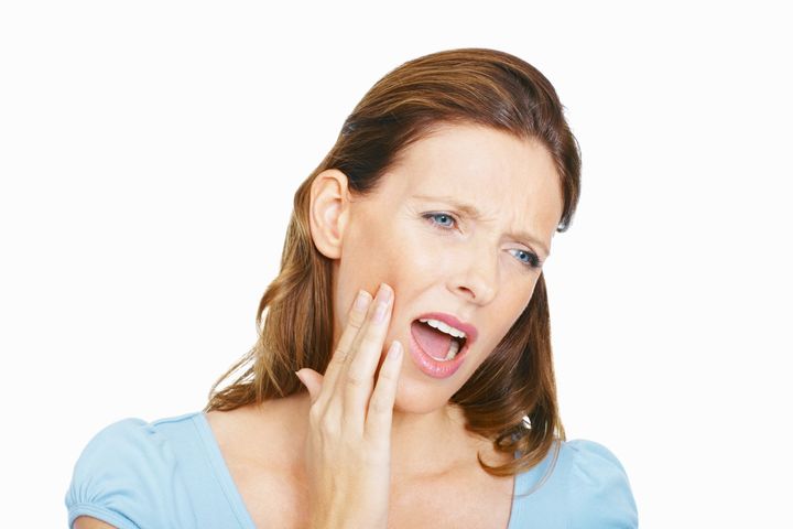 Painful tooth - Mid adult lady with hand on face