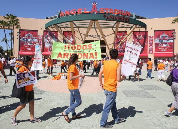 ANAHEIM, CA - JULY 13: Demonstrators hold signs protesting Arizona's strict SB1070 immigration bill before the 81st MLB All-Star Game at Angel Stadium of Anaheim on July 13, 2010 in Anaheim, California. (Photo by Stephen Dunn/Getty Images)