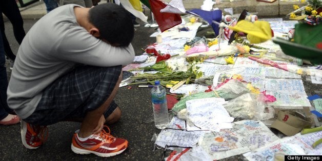 People visit a make-shift memorial on Boylston Street on April 20, 2013, near scene of Boston Marathon explosions as people get back to the normal life the morning after after the capture of the second of two suspects wanted in the Boston Marathon bombings. Thousands of heavily armed police staged an intense manhunt Friday for a Chechen teenager suspected in the Boston marathon bombings with his brother, who was killed in a shootout. Dzhokhar Tsarnaev, 19, defied the massive force after his 26-year-old brother Tamerlan was shot and suffered critical injuries from explosives believed to have been strapped to his body. AFP PHOTO / TIMOTHY A. CLARY (Photo credit should read TIMOTHY A. CLARY/AFP/Getty Images)