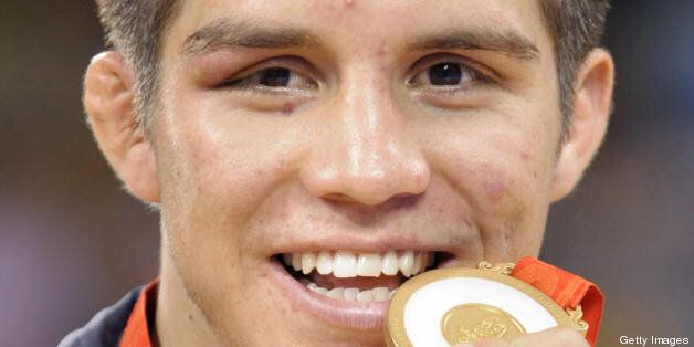 Henry Cejudo of the US shows off his gold medal after defeating Japan's Tomohiro Matsunaga in the men's 55kg freestyle gold medal match at the 2008 Beijing Olympic Games on August 19, 2008. AFP PHOTO / TOSHIFUMI KITAMURA (Photo credit should read TOSHIFUMI KITAMURA/AFP/Getty Images)