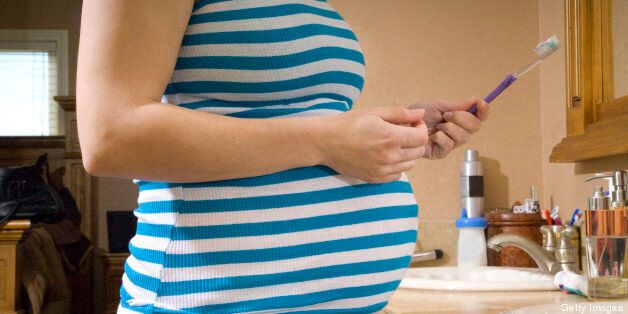 Pregnant woman holding her tooth brush