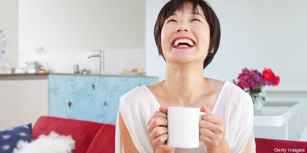 Smiling woman drinking cup of coffee