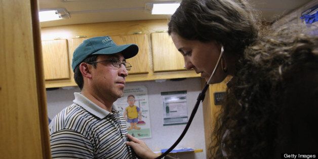 BRIGHTON, CO - APRIL 30: Physician's assistant Stephanie Miller checks the heart rate of an immigrant farm worker from Mexico during mobile clinic visit to a farm on April 30, 2013 in Brighton, Colorado. Salud family Health Centers sends a mobile clinic to farms throughout northeastern Colorado to serve the migrant population, many of whom ave little access to health care, which has become a major issue in health care reform proposals. (Photo by John Moore/Getty Images)