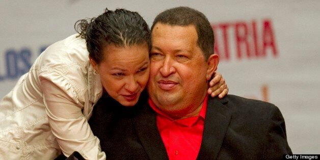 Venezuelan President Hugo Chavez is hugged by his daughter Rosa Maria's hand a during ceremony in Caracas on February on 23, 2012. Chavez has said he will travel on Friday to Cuba, where he is to undergo surgery early next week on a lesion in the same area where he had a cancerous tumor removed last year. AFP PHOTO/Juan BARRETO (Photo credit should read JUAN BARRETO/AFP/Getty Images)