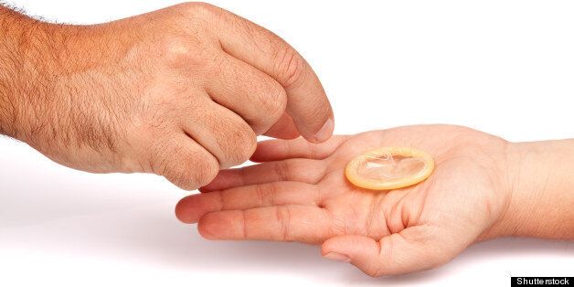man's hand grabbing a condom...