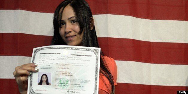 Elisannel Vargas Diaz holds her new citizen papers as her son looks on following a naturalization ceremony July 2, 2013 in New York. 150 immigrants, as part of similar events nationwide to mark the July Fourth holiday to the oath of citizenship. AFP PHOTO / TIMOTHY CLARY (Photo credit should read TIMOTHY CLARY/AFP/Getty Images)