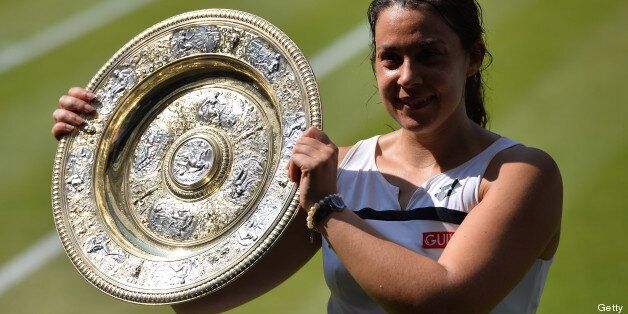 France's Marion Bartoli poses with the trophy after beating Germany's Sabine Lisicki in their women's singles final match on day twelve of the 2013 Wimbledon Championships tennis tournament at the All England Club in Wimbledon, southwest London, on July 6, 2013. AFP PHOTO / CARL COURT - RESTRICTED TO EDITORIAL USE (Photo credit should read CARL COURT/AFP/Getty Images)