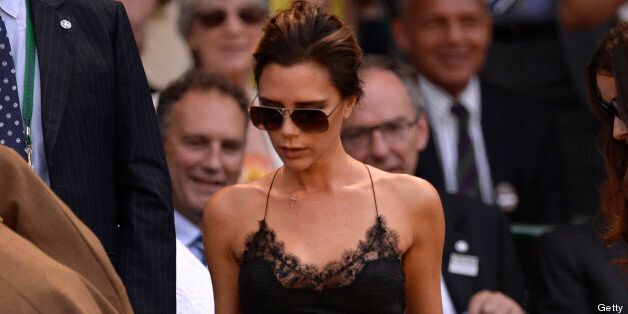 Fashion designer Victoria Beckham (C) arrives in the royal box to watch the men's singles final between Serbia's Novak Djokovic and Britain's Andy Murray on day thirteen of the 2013 Wimbledon Championships tennis tournament at the All England Club in Wimbledon, southwest London, on July 7, 2013. AFP PHOTO / ADRIAN DENNIS - RESTRICTED TO EDITORIAL USE (Photo credit should read ADRIAN DENNIS/AFP/Getty Images)